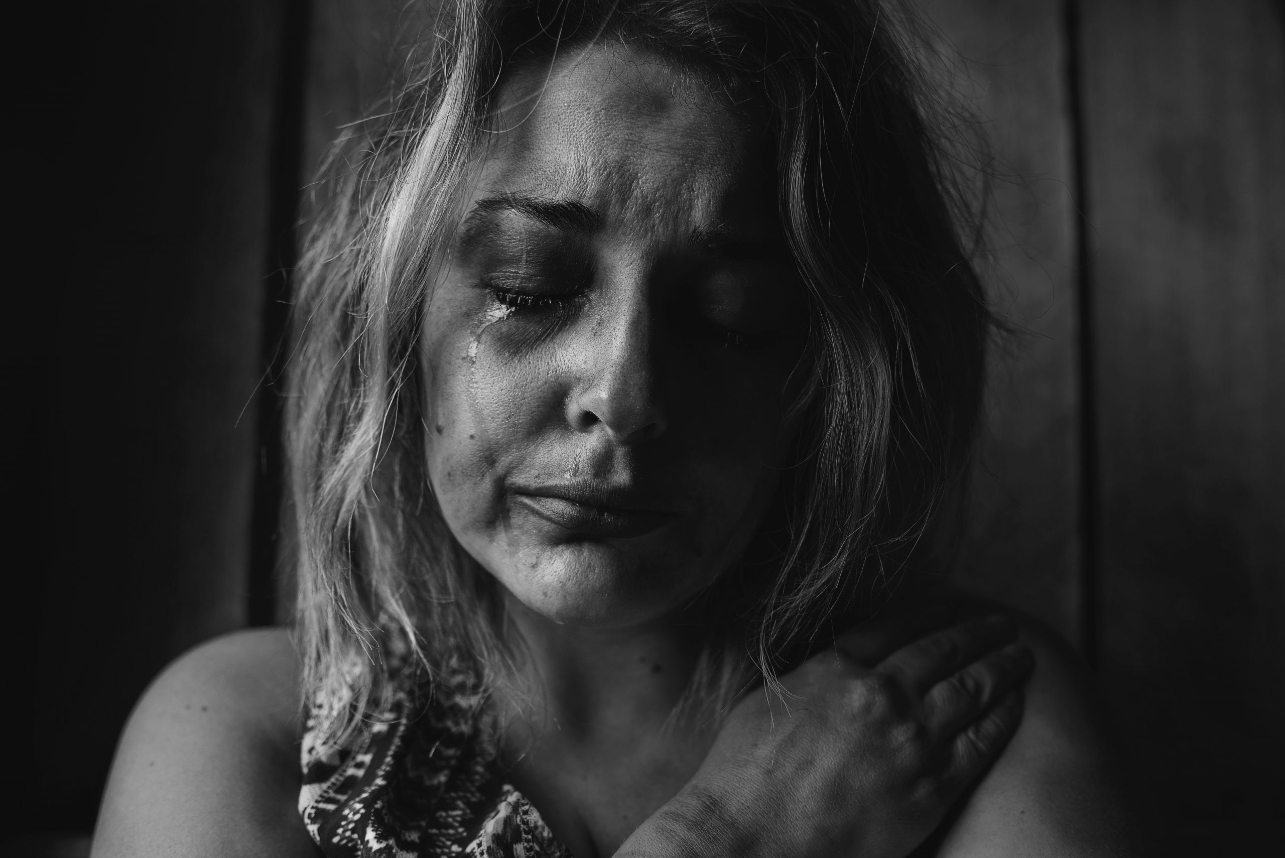 The BFD-grayscale photo of woman crying holding her right chest