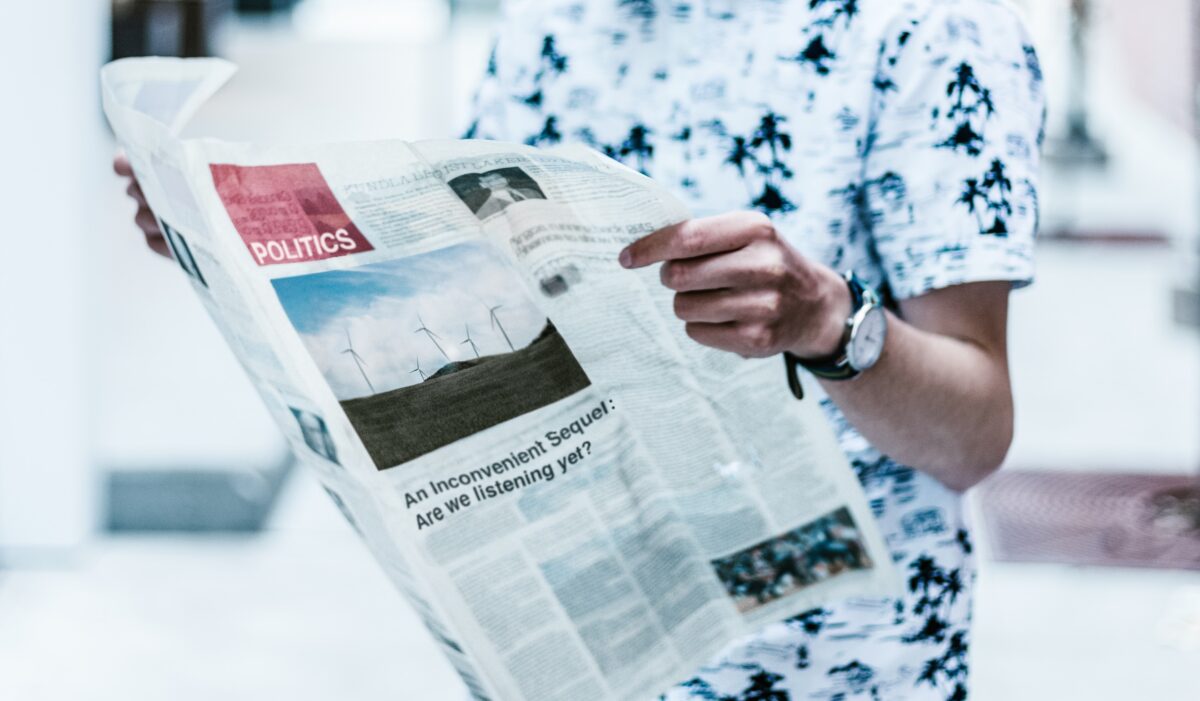 selective focus photography of person holding newspaper
