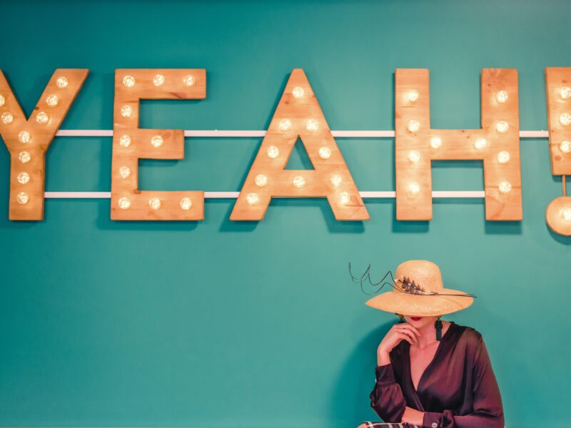 woman wearing brown hat near the yeah signage photography