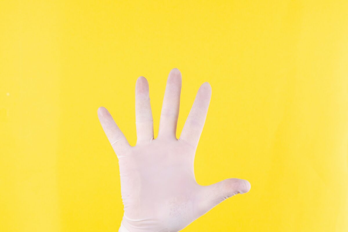 persons left hand on yellow background