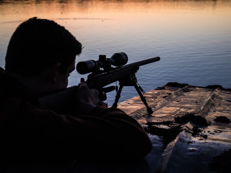man aiming sniper rifle at target