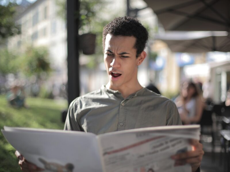 Shallow Focus Photo of Man Reading Newspaper