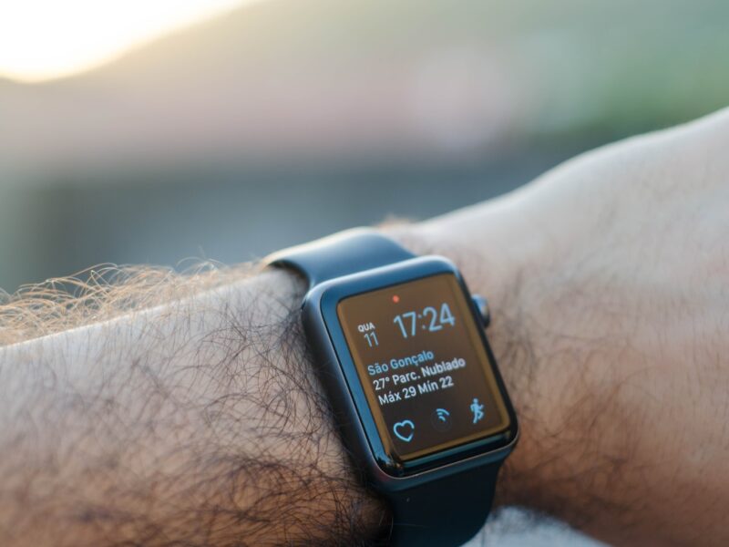 person wearing black smartwatch with black band