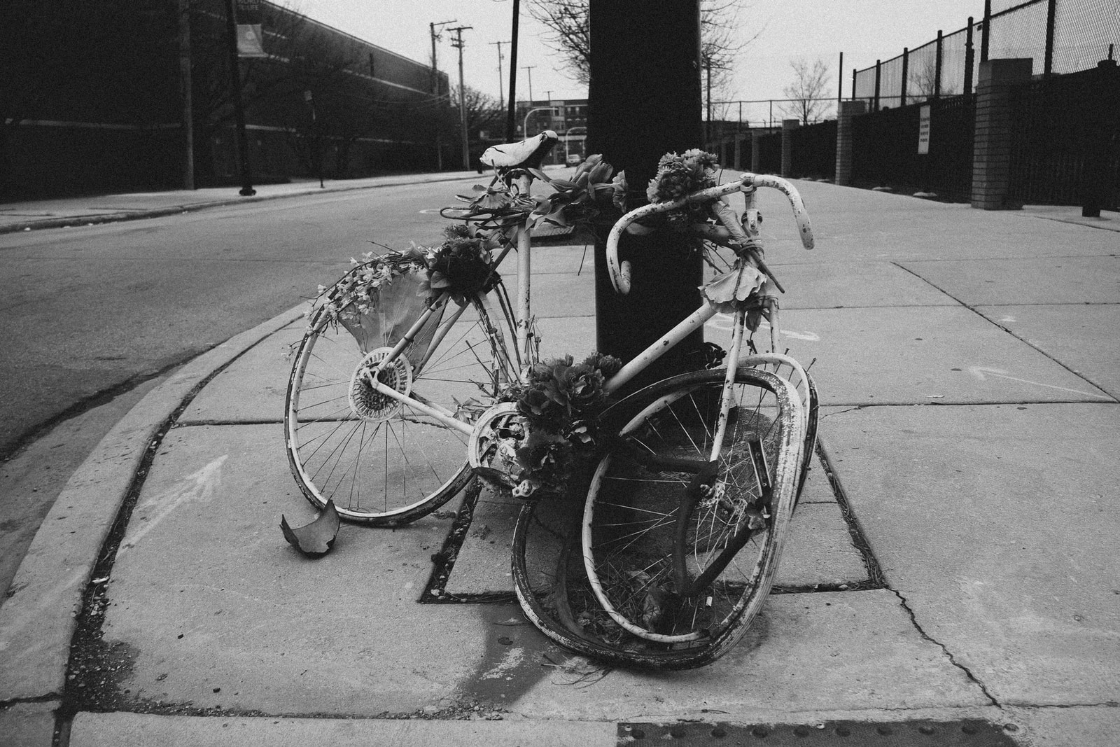 grayscale photo of bicycle parked on sidewalk