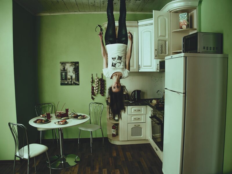 Woman Standing on Ceiling Inside Room