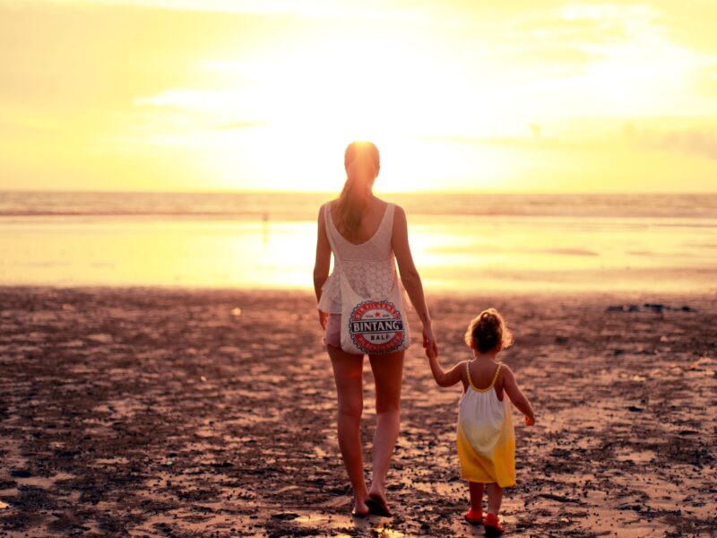 woman and child facing towards sunset