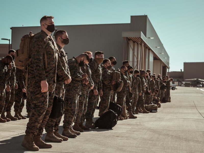men in black and brown camouflage uniform standing on brown floor