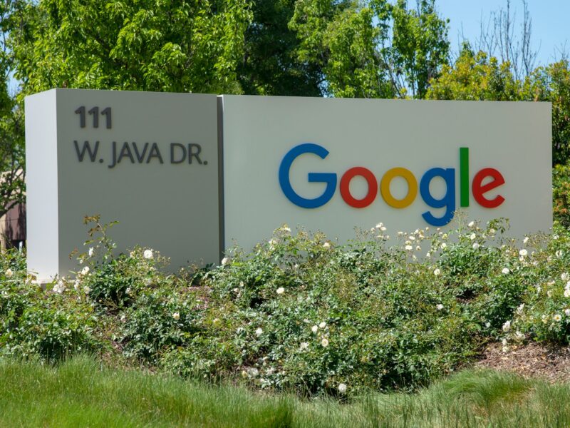 a google sign in front of some bushes and trees