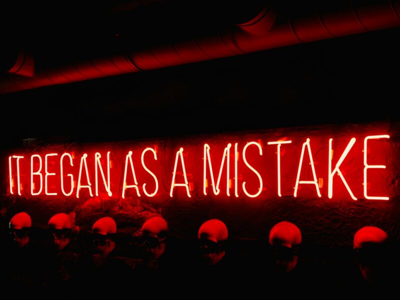 a neon sign that says it began as a mistake