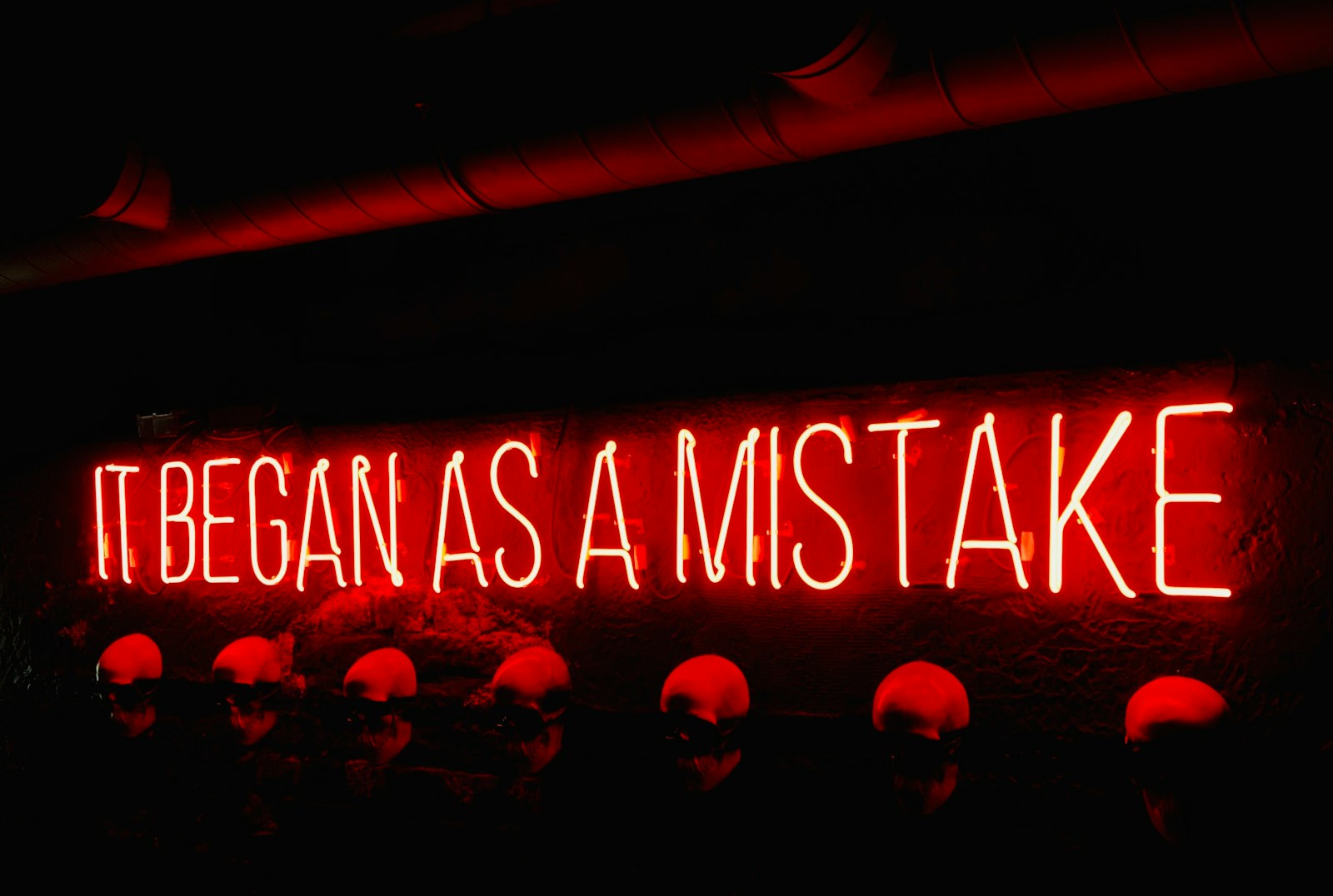 a neon sign that says it began as a mistake