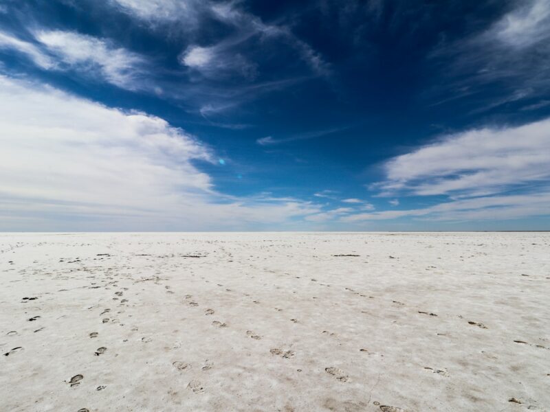 a vast expanse of white sand with footprints in the sand